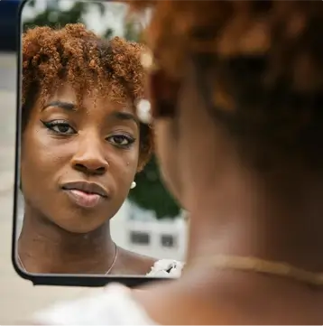 woman looking at herself in mirror