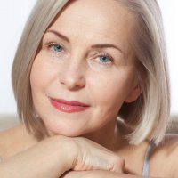 Beauty Woman with perfect skin Portrait. Beautiful middle-aged blonde woman shows off her perfectly well-groomed face. Plastic surgery and collagen injections. Macro face. Selective focus on face. Realistic images with their own imperfections.